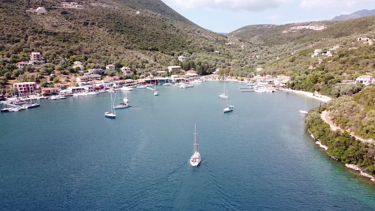 Luxury Boat Sails to Port at Mikros Gialos, Lefkada, Greece - Aerial Follow