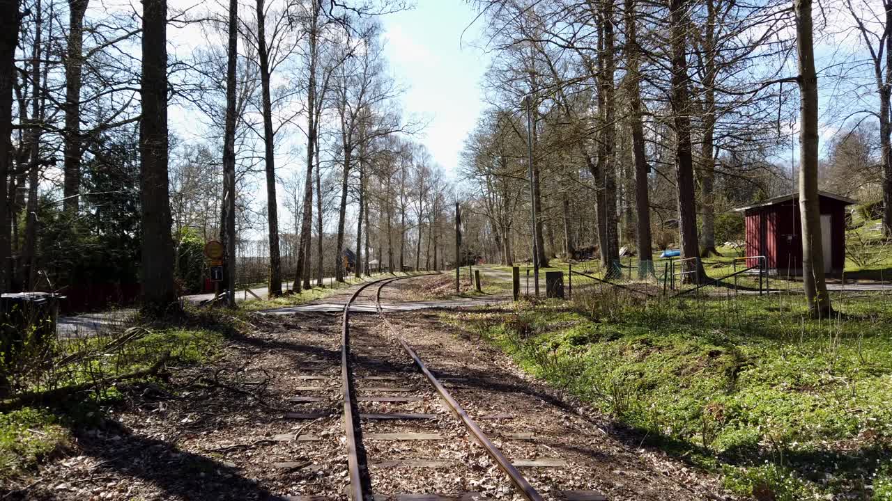 vías férreas del tren que conducen a través de un paisaje de bosques durante la primavera