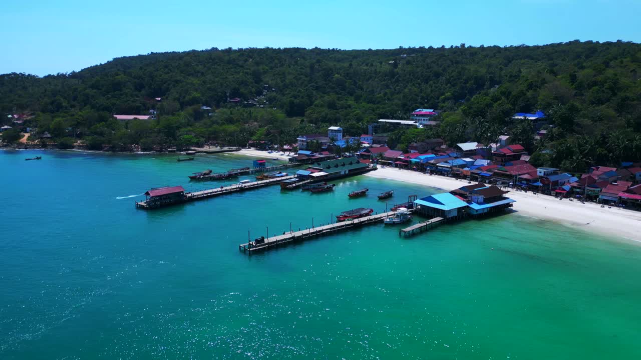 koh rong island in Cambodia, featuring turquoise water, pier, boats and tropical jungle. Beautiful aerial view flight wide orbit overview drone