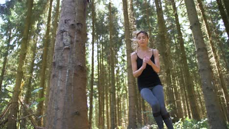 low angle view of a woman exercising her legs by jumping back and forth over a fallen log