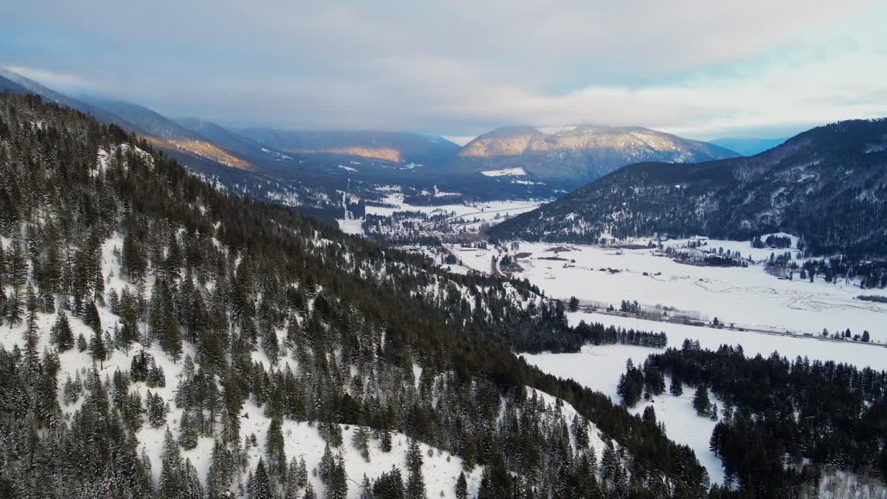 Winter Sunset Magic: Tracking Shot Flying Sideways over Tree-Covered Mountains in the Thompson-Nicola Region, BC, Canada with Light Clouds