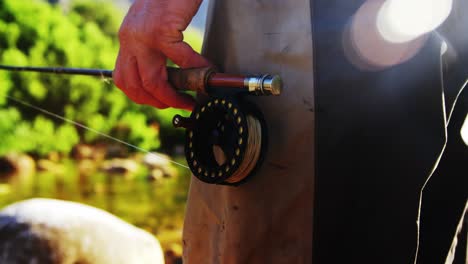 Pescador-Con-Mosca-De-Pie-En-La-Roca-Con-Caña-De-Pescar.