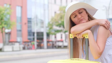 a woman sitting on a suitcase outdoors in an urban setting. the concept of being late or canceling a flight