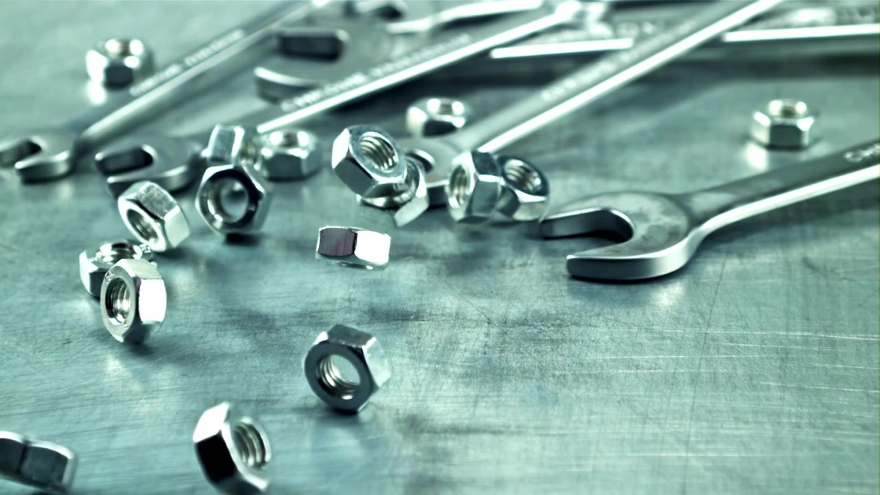 Metal Nuts Falling in Slow Motion onto a Metallic Surface
