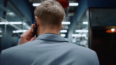 Closeup-man-looking-around-in-office.-Businessman-having-phone-conversation