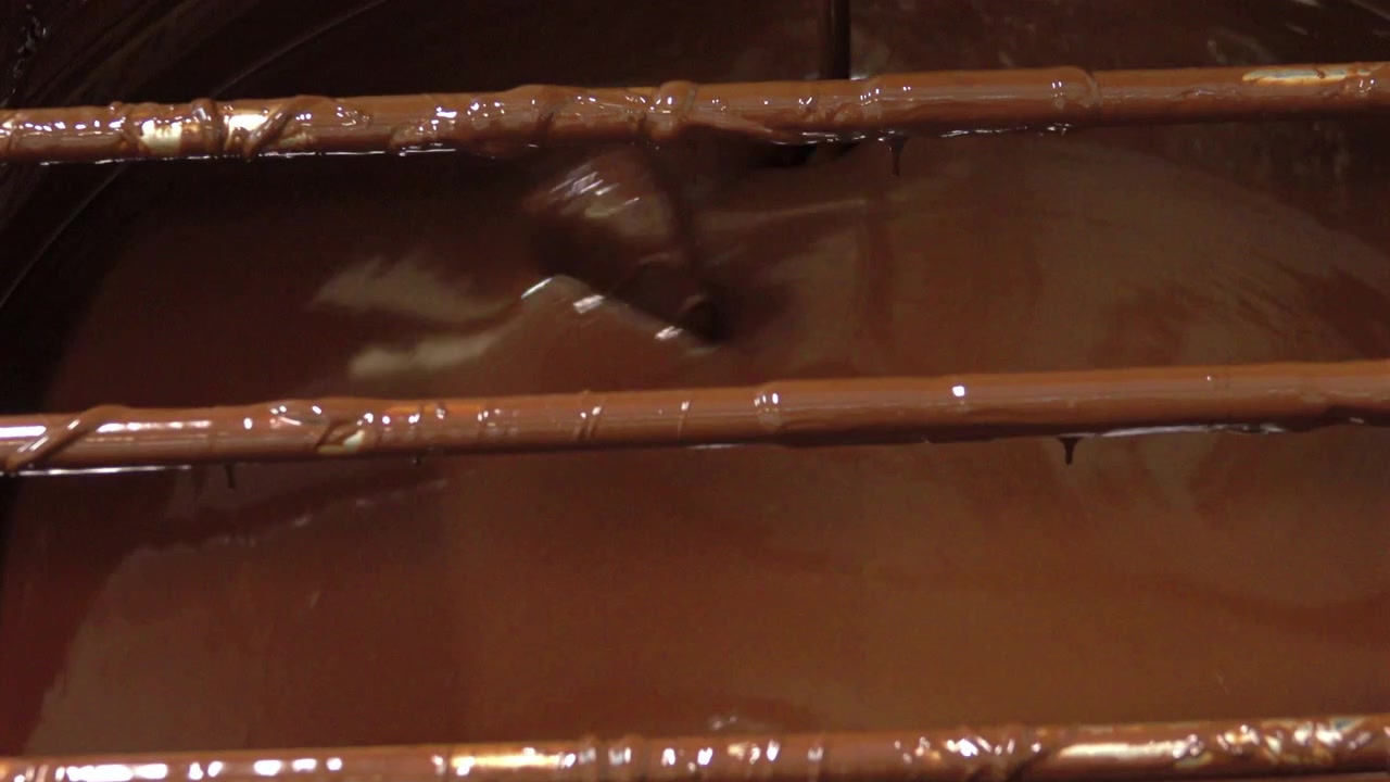 Una vasca di cioccolato fuso in una fabbrica di cioccolato artigianale.