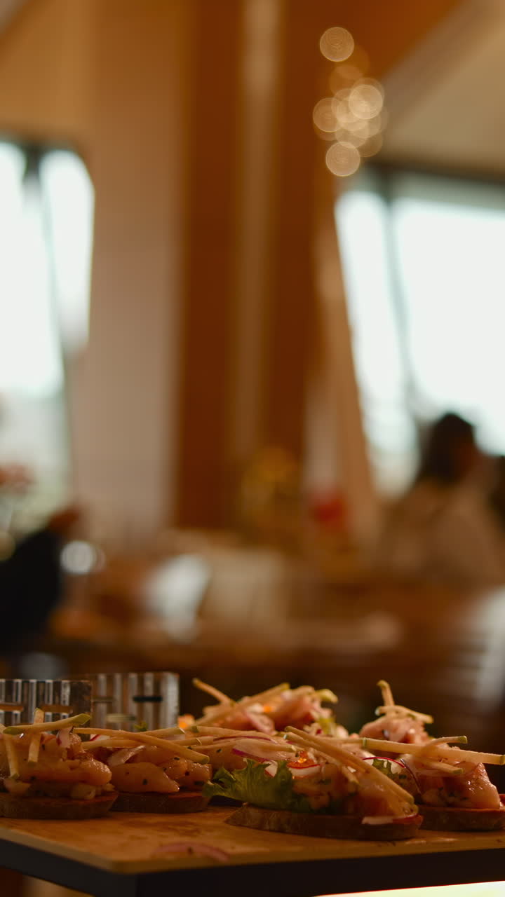 Aperitivos gourmet em uma bandeja com pessoas desfocadas ao fundo