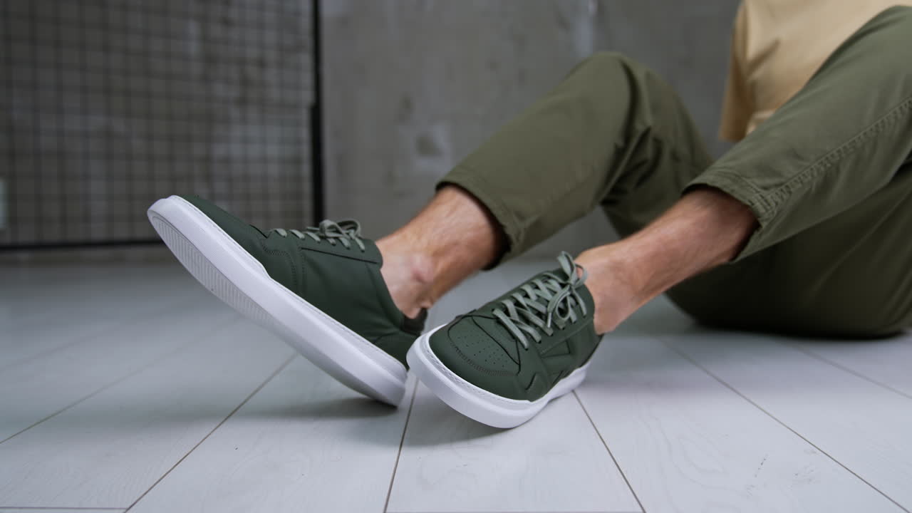 Man Sitting in Olive Green Pants with Green Sneakers