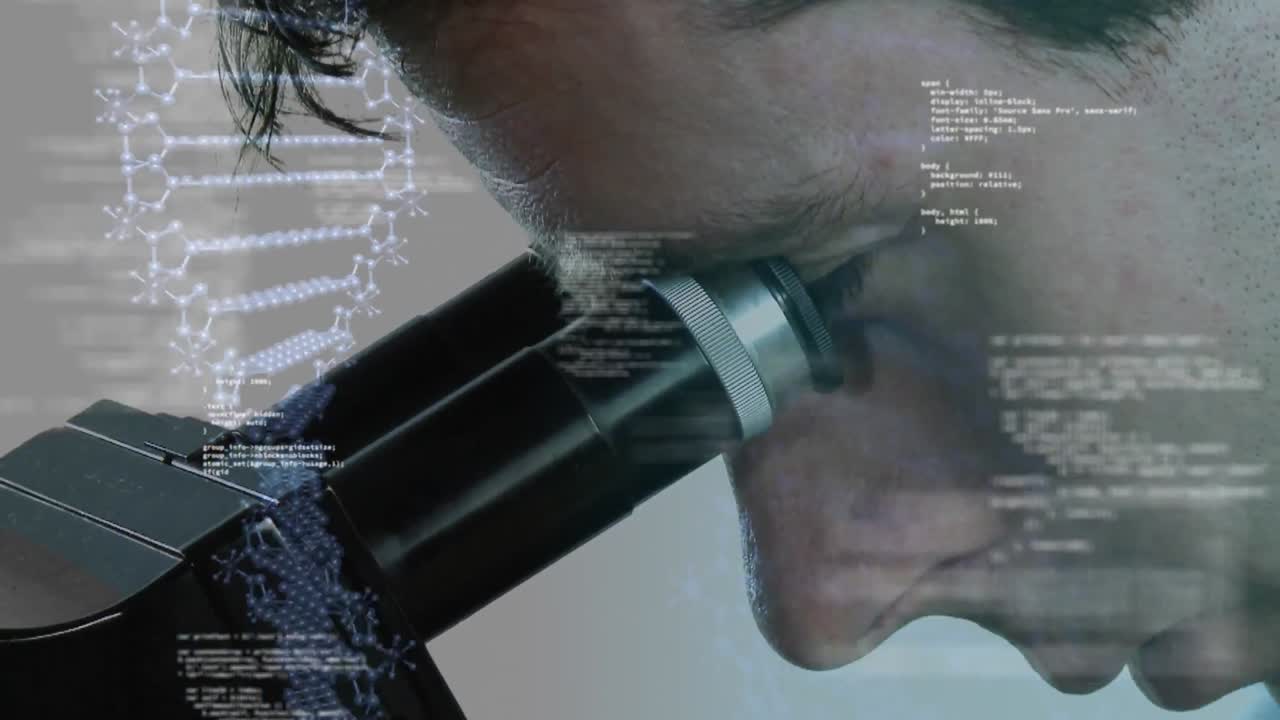 Scientist peeking in to a microscope