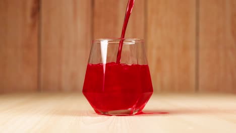 red drink poured into geometric glass on table