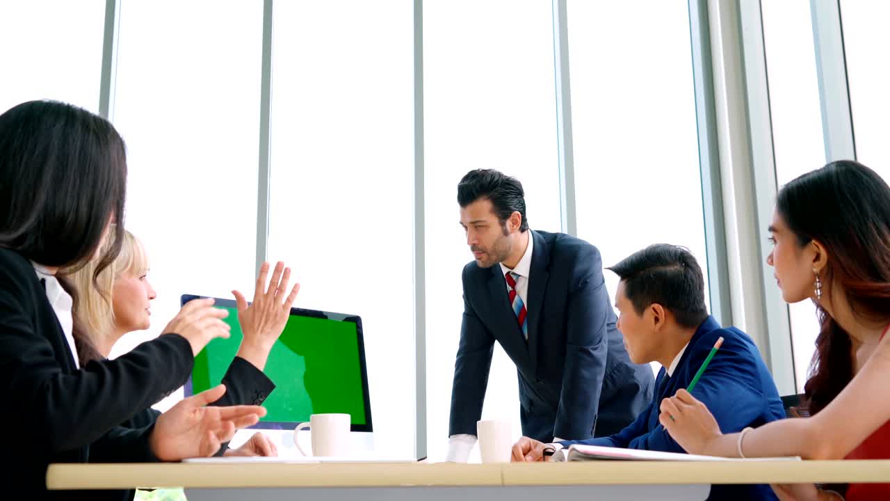 녹색 스크린을 가진 회의실에 있는 비즈니스 사람들