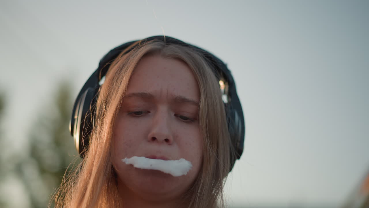 white girl eating cotton candy closeup, playful foodie at fairground, sugar moustache, fingers pulling fluffy treat, candid snacking action, warm sunset light, influencer style casual