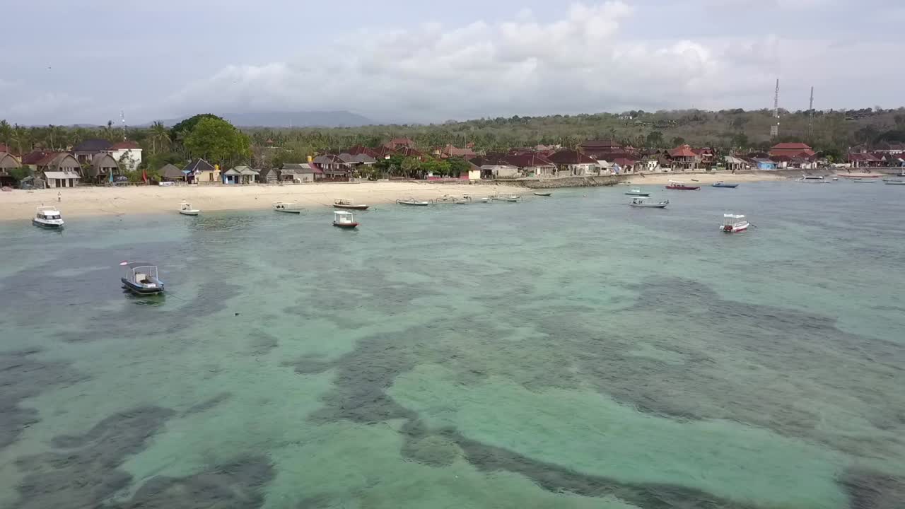 dramática vista aérea rápida vuelo volar hacia adelante imágenes de drones sobre el arrecife sobre aguas turquesas cristalinas, barcos a la playa tropical bali en la bahía de hongos