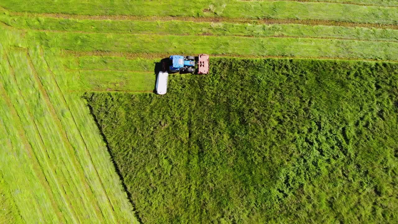 Tractor with double mower filmed during hay harvest