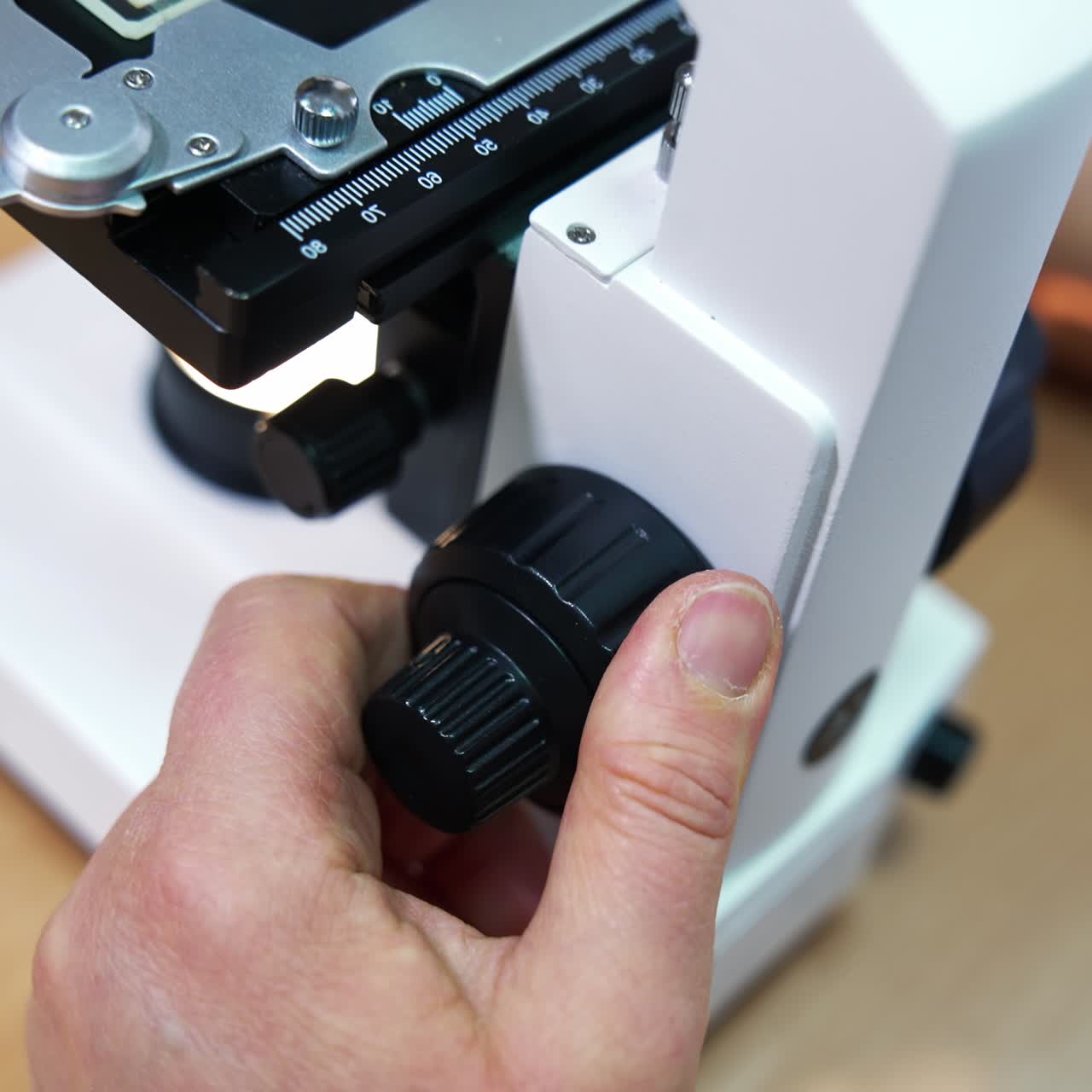 Adjusting microscope lenses into a necessary position. Laboratory research in medical care centre. Close up