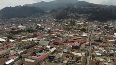 city aerial tilts to streets of quetzaltenango in guatemala mountains