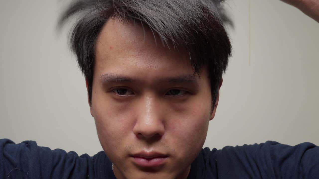 젊은 중국인 남자가 안전 스포츠 안경을 벗습니다.