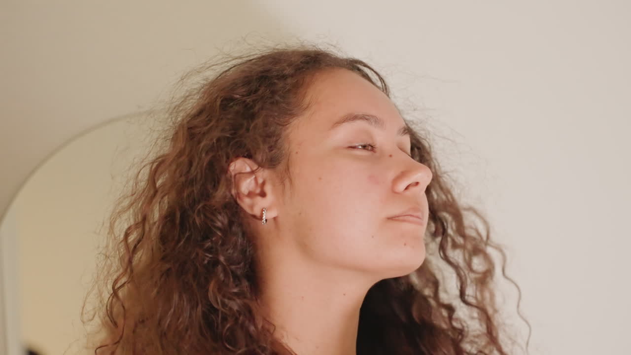 Rituale di bellezza in suite lussuosa. Un'ospite sofisticata si dedica a pratiche di cura personale lussuose. Un'elegante visitatrice dell'hotel si dedica a una serena ed elegante sessione di toeletta in un ampio bagno.