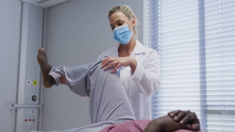 diverse female orthopedic doctor examining male patient in face masks