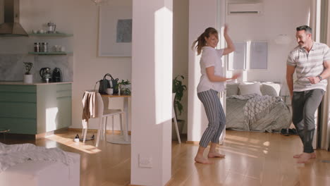 happy-young-couple-dancing-at-home-enjoying-dance-together-having-fun-celebrating-relationship