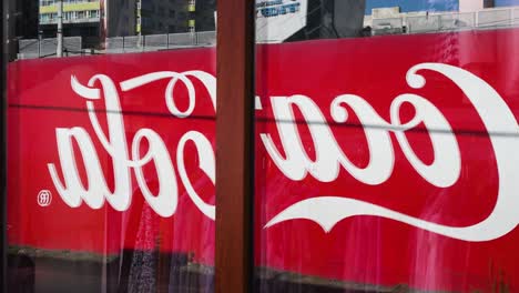 coca-cola sign reflected in a window