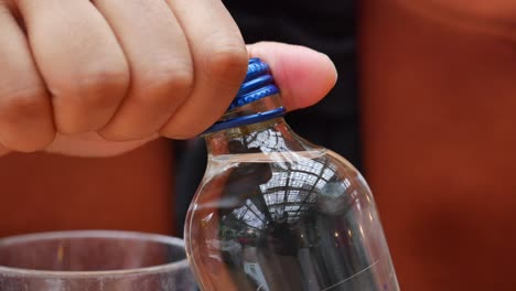 close up of a hand opening a water bottle