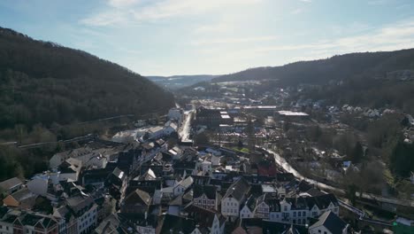 wide-angle aerial view of the entire old town, surrounded by lush green hills.
