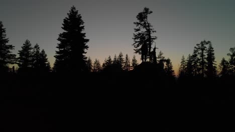 rotating aerial of photographers silhouette against dusk sunset sky