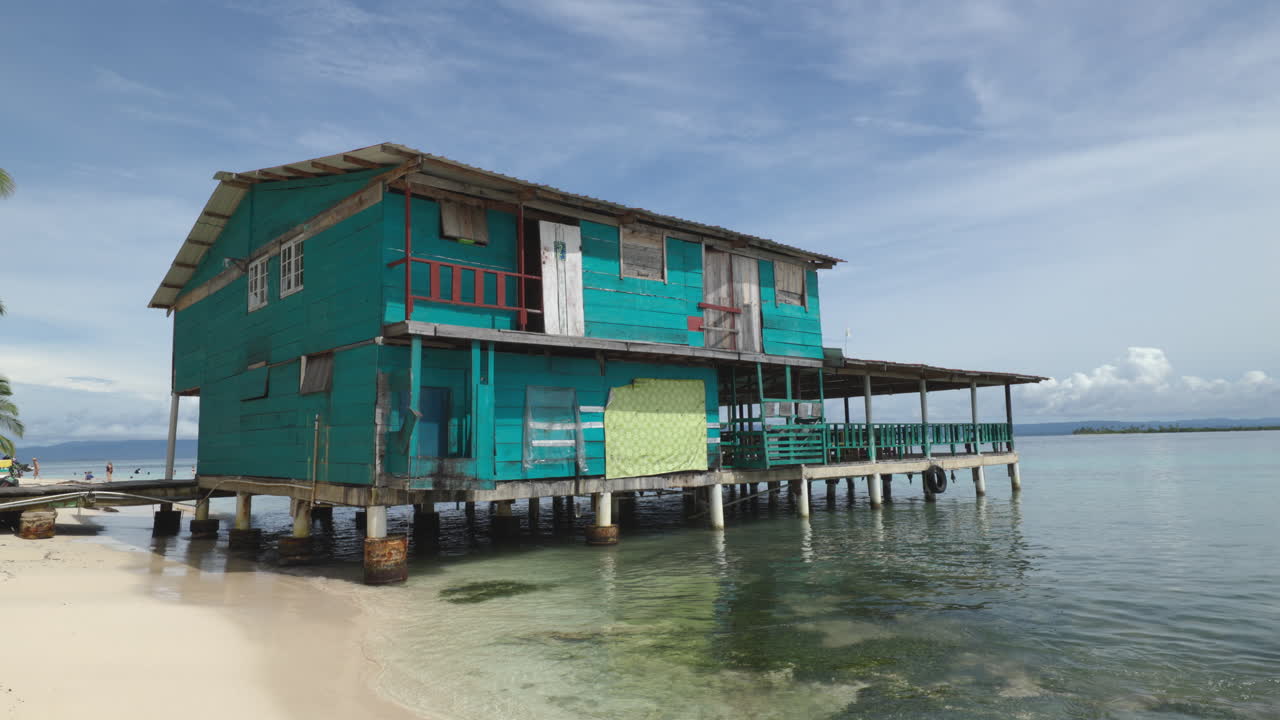 casa flotante turquesa con algunas personas nadando en