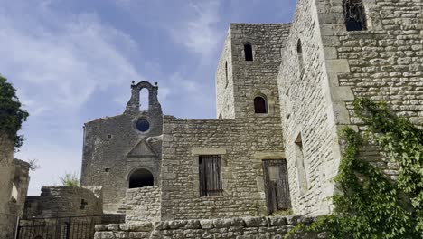 small stone church behind frosted historic stone house small chapel in the heat of france