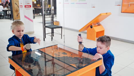 children playing with sand and iron powder in entertaining and educative centre
