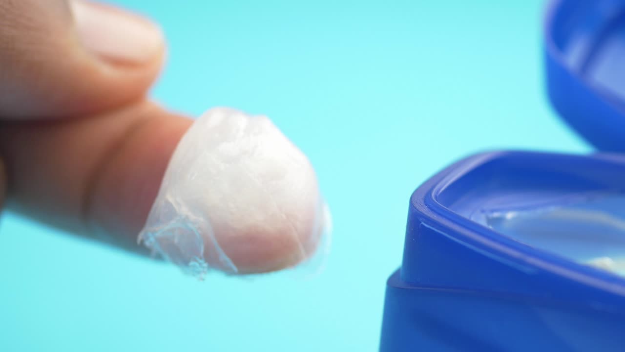 un primer plano de alguien aplicando crema blanca