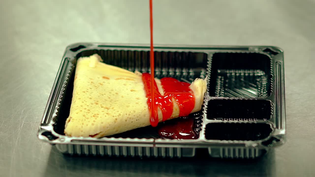 요리사는 입맛있는 팬케이크에 딸기 시럽을  ⁇ 습니다.