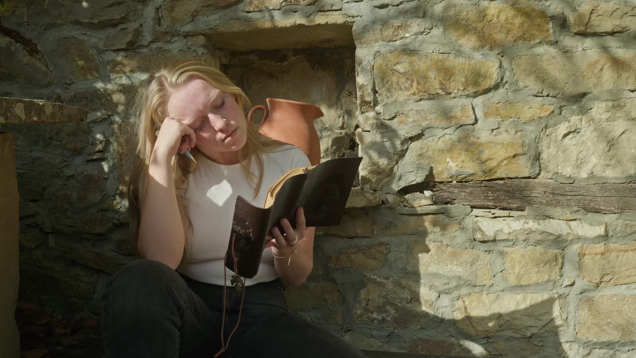 깊은 생각에 빠진 젊은 여성은 사적인 일기를 쓰고 평화로운 고립