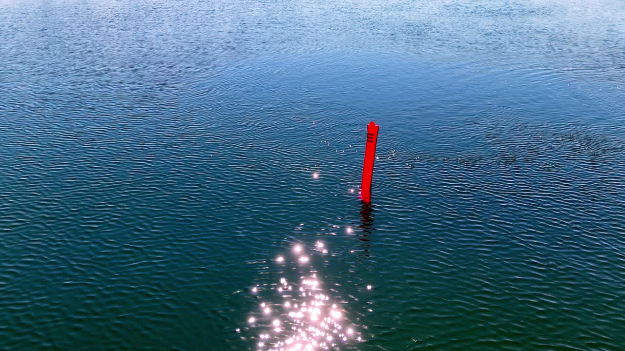 Red Delayed Surface Marker Buoy For Divers In Glistening Lake Water In Latvia