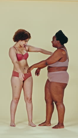 two smiling women embracing in underwear