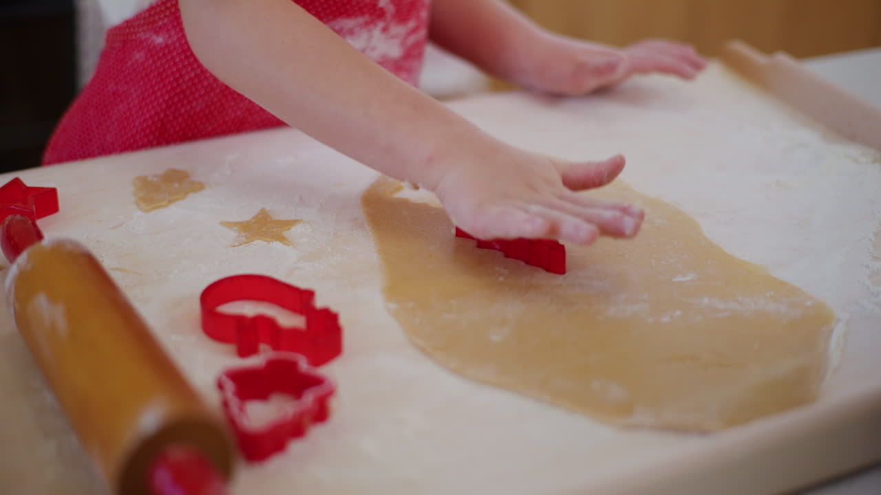 A Young Boy Cuts Out Gingerbread Cookie Shapes