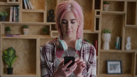 portrait of young punk woman using smartphone texting browsing online enjoying mobile communication independent female funky pink hair real people series