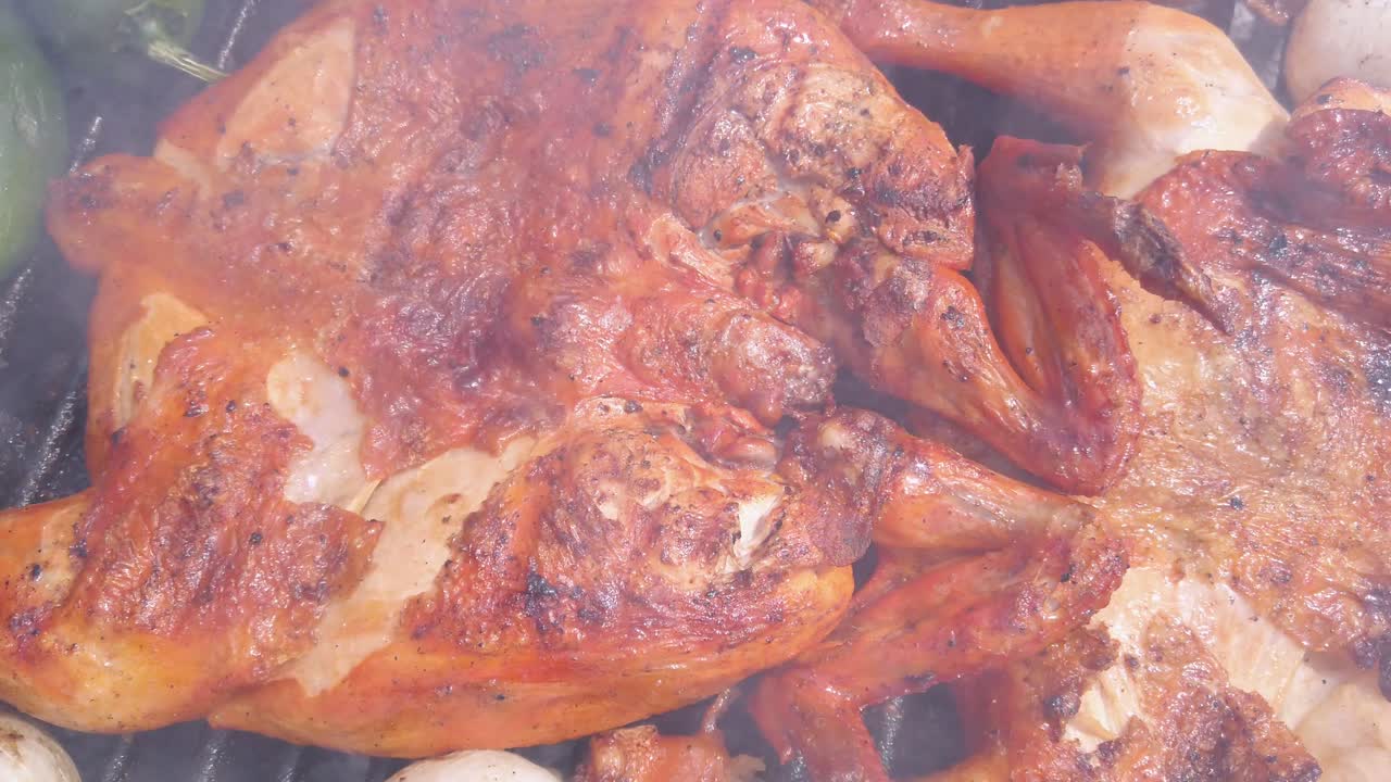 Spicy grilled chicken and jalapeño peppers cooking on a hot barbecue grill