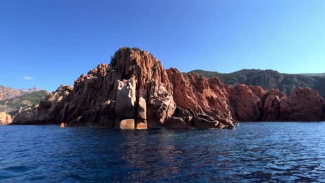 paisaje primitivo de las calanques de piana formaciones rocosas erosionadas volcánicas en la isla de córcega como se ve desde un barco en movimiento en la temporada de verano, francia