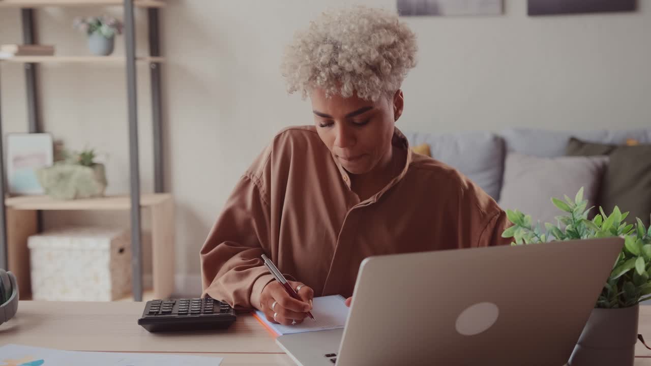 African woman calculates domestic bills pay loan payments online on laptop