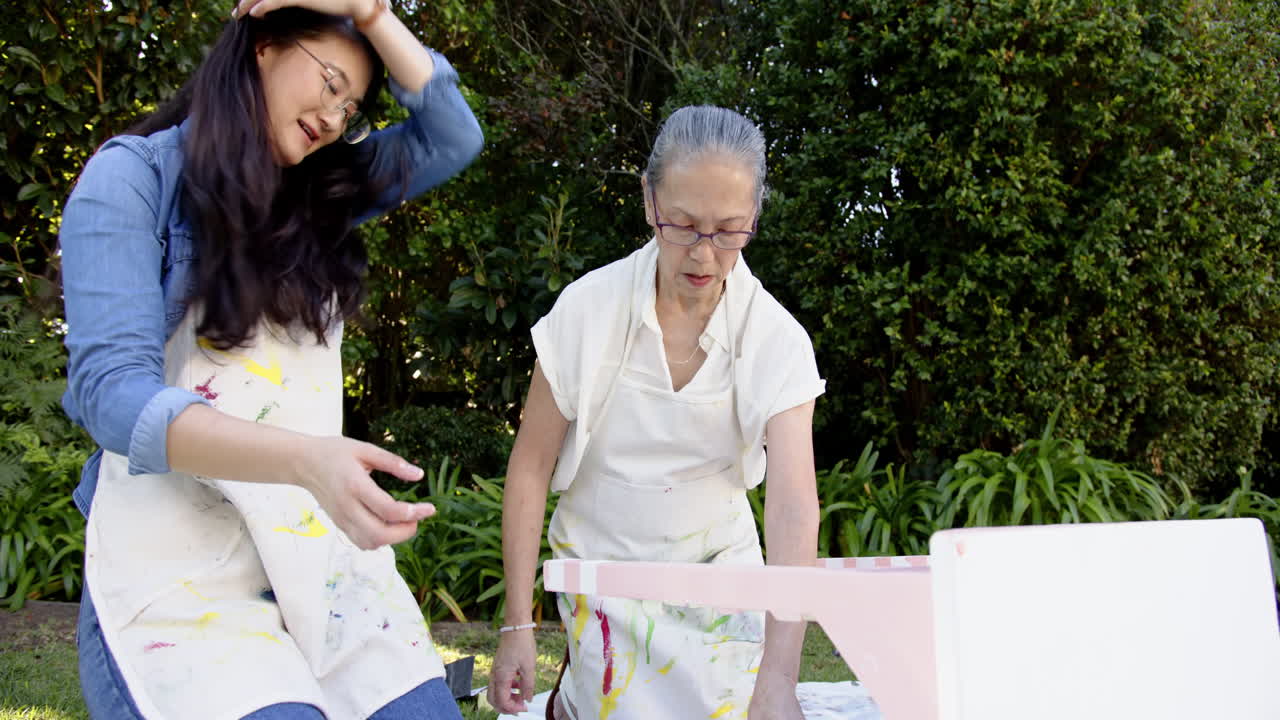 Upcycling furniture, asian grandmother and granddaughter painting together, copy space