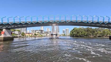 ferry travels under bridge on scenic river