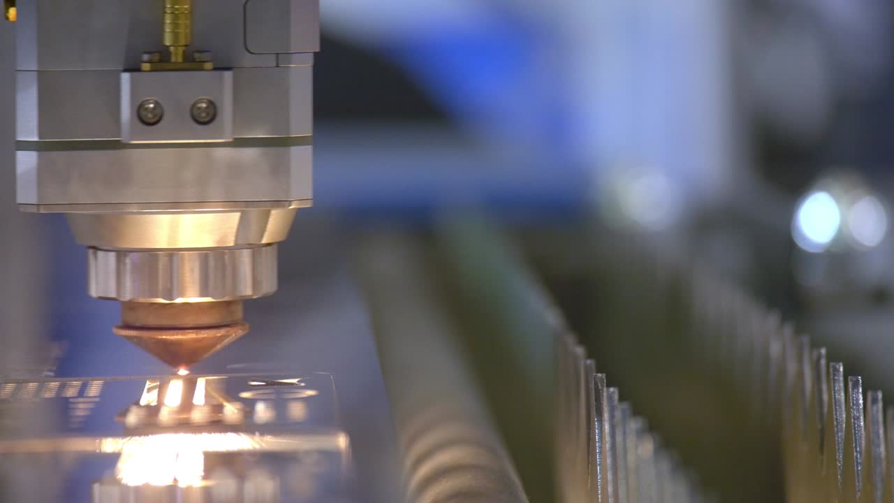 금속의 절단 - 레이저에서 스파크가 날아갑니다 - 스파크를 가진 산업용 레이저 절단기 - 프로그래밍 된 로 머리는 거대한 금속 온도 시트의 도움으로 절단합니다.