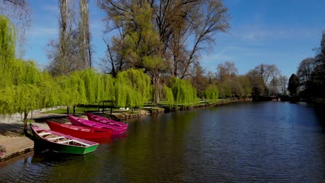 Paraíso-Parque-Tranquilo-Con-Barcos-Anclados-En-La-Orilla-Del-Canal-Bajo-Sauces-Verdes-En-Un-Soleado-Día-De-Primavera