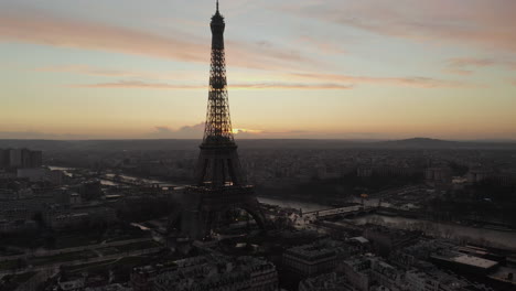 Aerial-shot-of-Eiffel-Tower-silhouette-against-twilight-sky.-Large-city-at-dusk-in-background.-Paris,-France