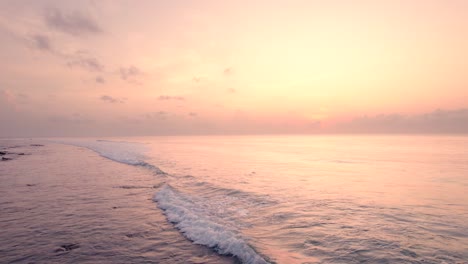 una toma de las olas tranquilas del océano en movimiento hacia atrás durante el amanecer.