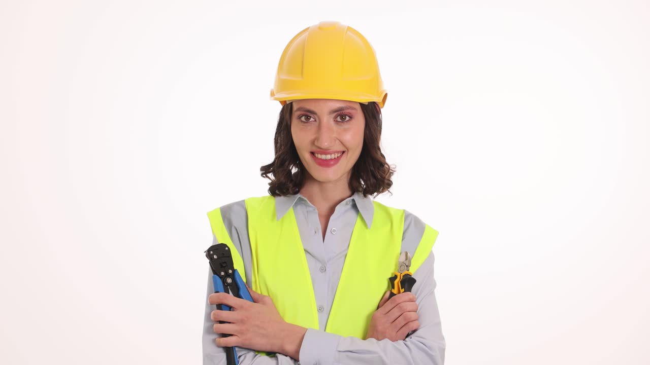 Confident Female Engineer or Construction Worker in Hard Hat and Safety Vest Holding Tools