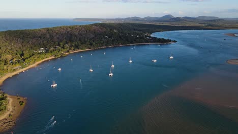 sailboats anchored at coral sea near the seashore of 1770 town in qld, australia