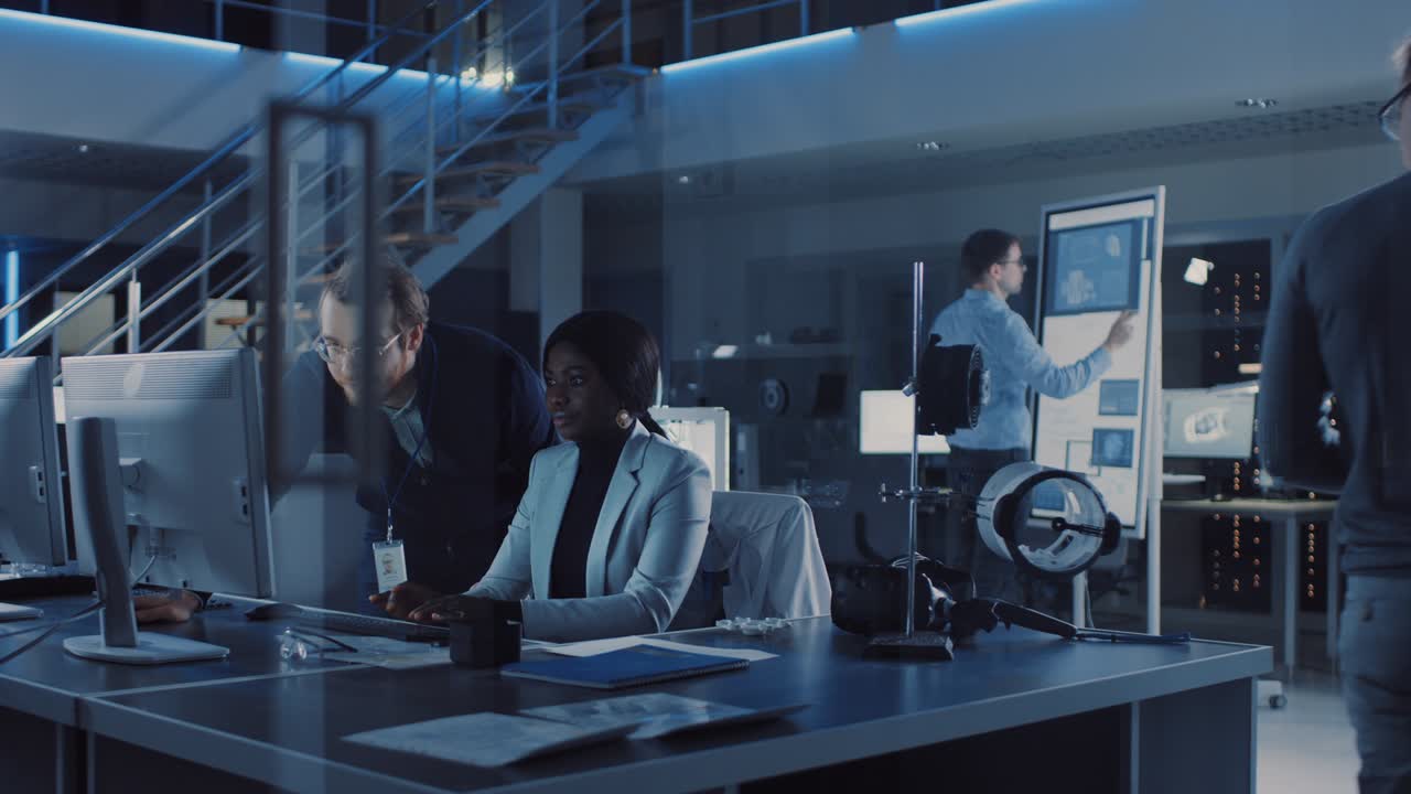 Electronics Development Engineer Working on Computer, Talks with Project Manager. Team of Professionals Use Digiral Whiteboard, Tablets and CAD Software for the Modern Industrial Engineering Design.